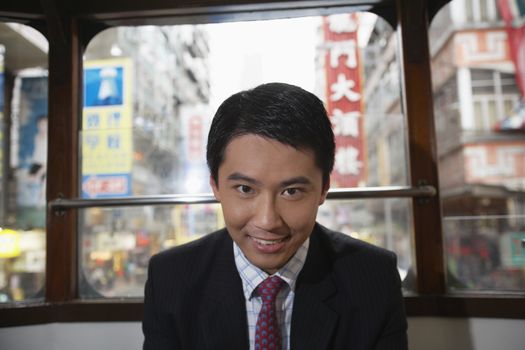 China Hong Kong business man sitting in double Decker tram portrait