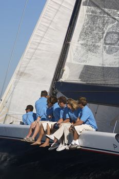 Sailing team sitting on sailboat