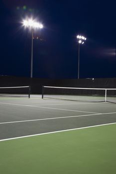 Outdoor tennis court illuminated at night