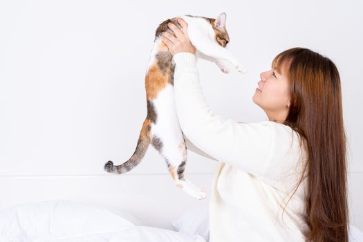 Woman at home holding her lovely fluffy cat. Multicolor tabby cute kitten. Pets and lifestyle concept.