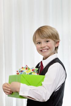 Portrait of a cheerful young birthday boy with gift