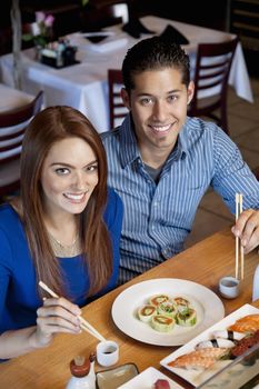 Portrait of a happy couple with Japanese cuisine