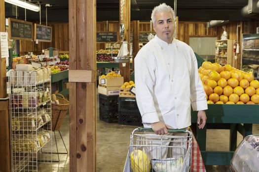 Portrait of a mid adult chef with shopping cart in farmer's market