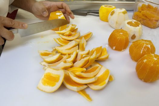 Close-up of hands slicing oranges with knife