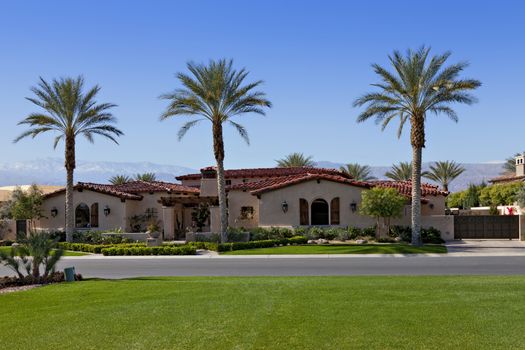 View across grass to façade of luxury suburban villa