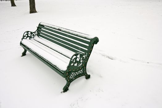 Park bench covered in snow