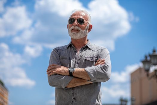 Old rich man with sun glasses and beard on street portrait
