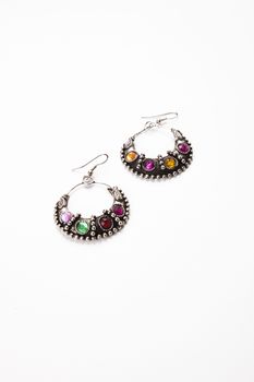 Colorful gems on earrings over white background