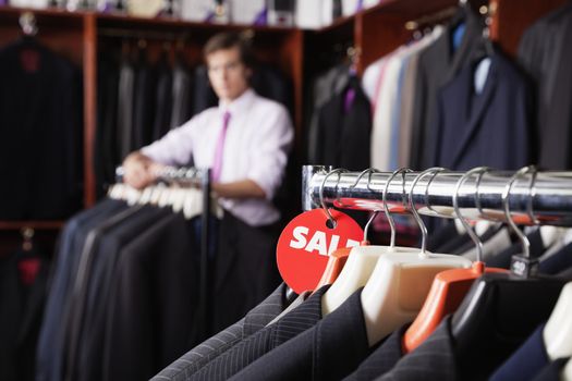 Close-up of suits hanging on rack with price tag in store