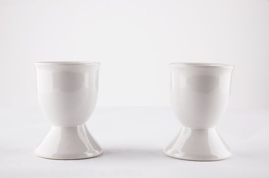 Empty egg cups side by side over white background