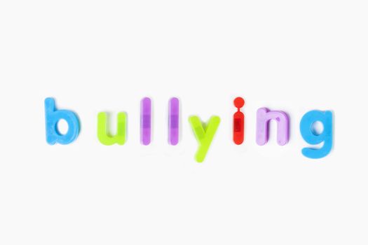 Colorful alphabet magnets spell 'bullying' over white background