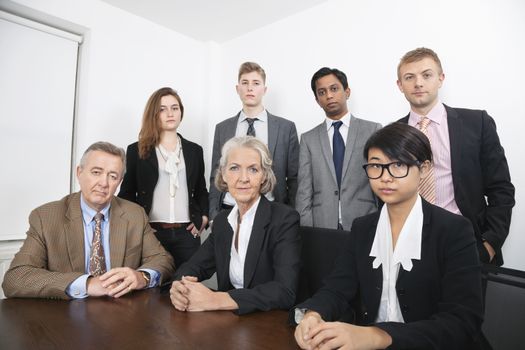 Portrait of confident multiethnic business group at desk in office