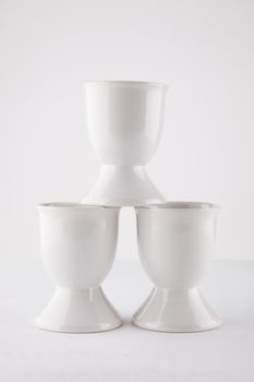 Close-up of empty egg cups arranged against white background