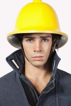 Portrait of young fireman against gray background
