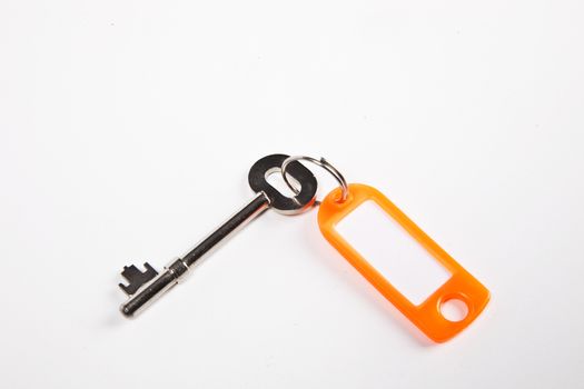 Key with orange key ring tag on white background