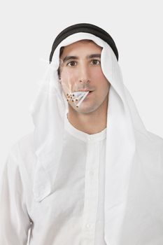 Portrait of an Arab man smoking cigarettes over white background