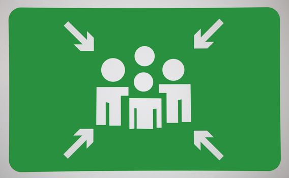 Arrow signs towards human representation on green surface