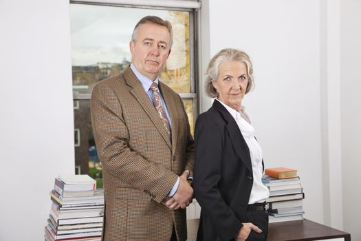 Portrait of confident businessman and woman in office