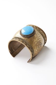 Blue gem on traditional bracelet over white background