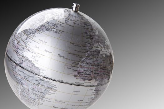 Close-up of silver globe over gray background