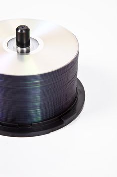 Stack of compact discs on a spindle over white background