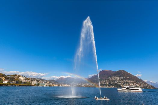 Panorama view of Lugano Lake and city  with fountain and rainbow