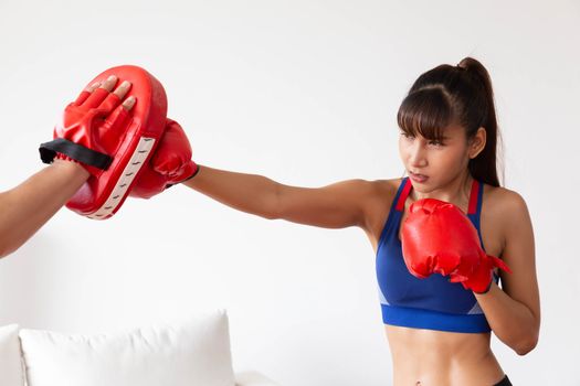 An asian women has boxing training with trainer by punch the tar