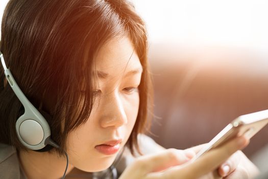 Young woman listening music from mobile phone