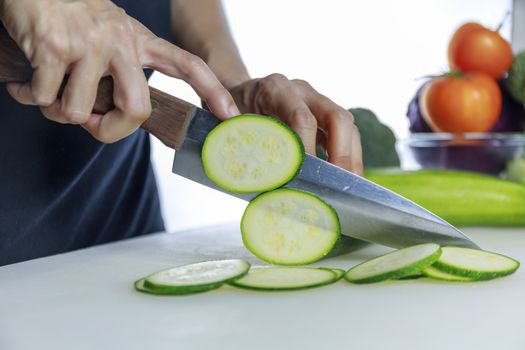 Close up hands women holding knife and cuting fresh Courgette on