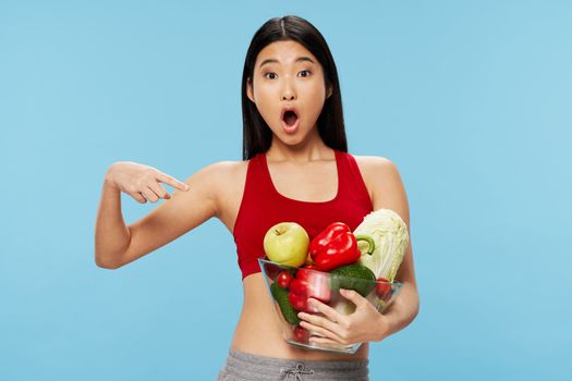 Girl shows on a plate with vegetables and slim figure calorie