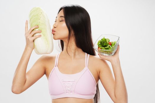 slim woman in pink t-shirt with salad in a plate and calorie