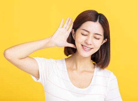 young woman listening to something by putting hand on the ear