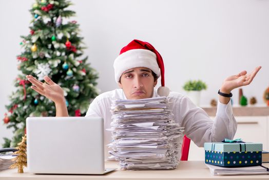 Young worker working in office on christmas shift