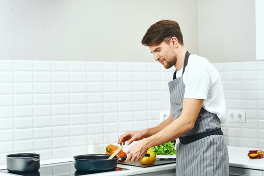Male chef cashier aprons in the kitchen preparing food Professional