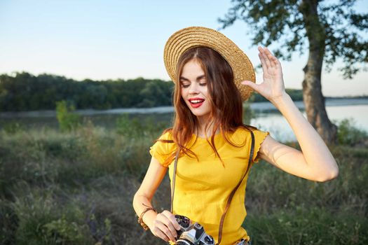woman with camera wearing hat red lips closed eyes nature lifestyle. High quality photo