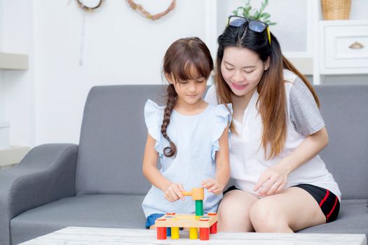 Asian kid girl and mother playing toy block; together with cheer