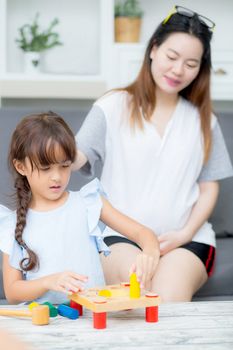 Asian kid girl and mother playing toy block; together with cheer