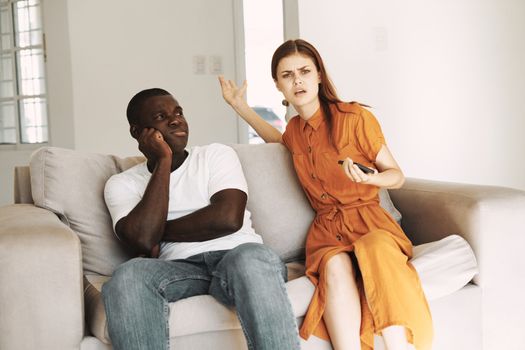 Man and woman in the living room on the couch emotions of communication with a phone in their hands