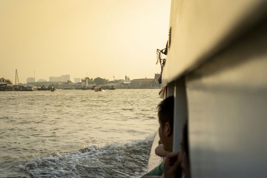 people enjoying a cruise with view on the Chao Phrya river in Bangkok, Thailand during sunset