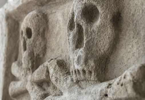 Ancient stone skull with crossbones