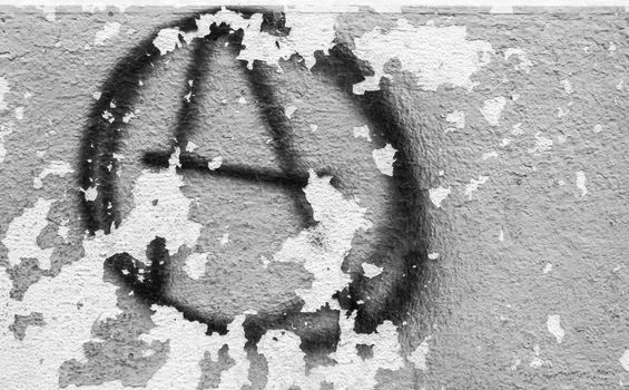 Symbol of anarchy painted on the peeling old wall