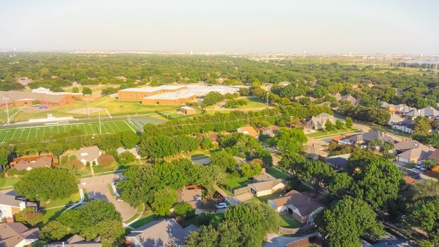Aerial view residential neighborhood in school district with football field in near Dallas, Texas, USA