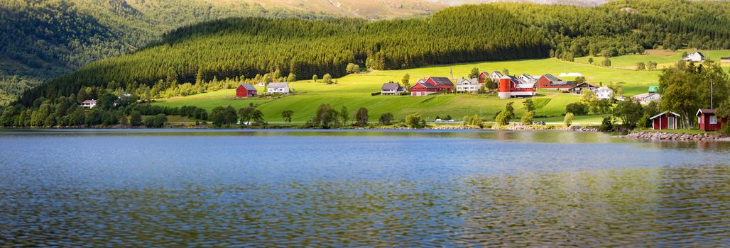 Norway country houses. Lake and meadows. Reflection in water. Nordic, Scandinavia, Europe travel