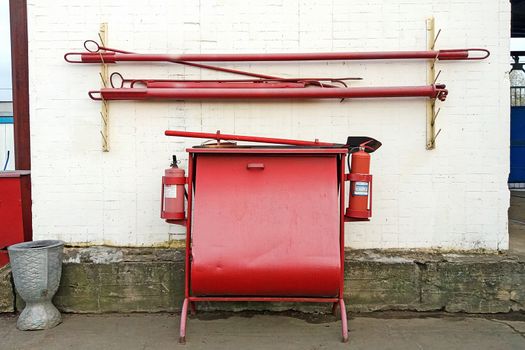 firefighting equipment stand with sandbox, extinguishers, spades and fire hooks