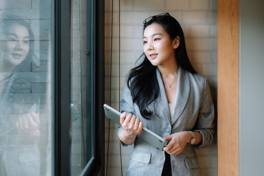 Portrait of smiling millennial businesswoman holding laptop computer