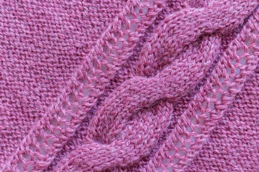 Openwork pattern knitted with needles from pink wool yarn.