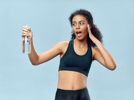 Pretty woman holding a bottle of water in her hand Healthy fitness sport