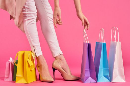 shopping bags female feet in shoes Shopaholic pink background