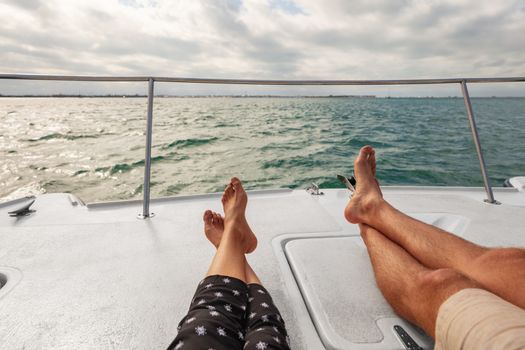 Yacht boat lifestyle couple relaxing on cruise ship in Hawaii holiday . Two tourists feet relax getaway enjoying summer vacation