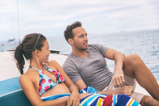Yacht boat lifestyle couple talking on cruise ship in Hawaii holiday . Two tourists getaway enjoying summer vacation, woman relaxing in bikini